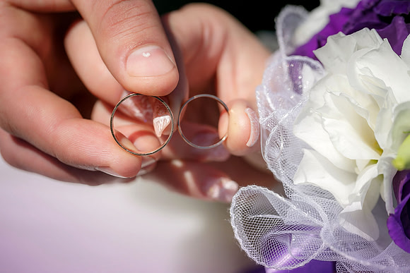 bride and groom holding hands in a ring
